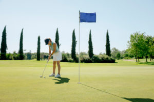 Woman playing golf on golf course Woman playing golf on golf course